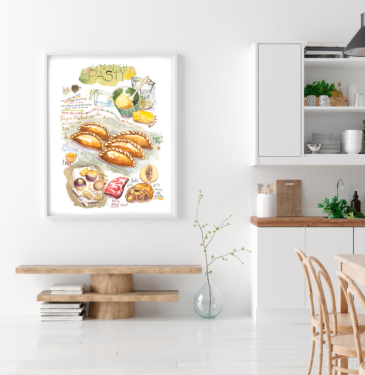 Cornish pasty recipe fine art print in watercolor featuring the ingredients and the finished dish, along with handwritten instructions in English. The framed poster hanging in a Kitchen.