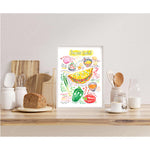 Denver omelet recipe fine art print in watercolor featuring the ingredients and the finished dish, along with handwritten instructions in English. The framed poster hanging in a kitchen space.