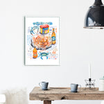 steamed blue crab recipe fine art print in watercolor featuring the ingredients and the finished dish, along with handwritten instructions in English. The framed poster hanging in a dining space.