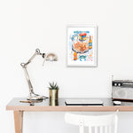 steamed blue crab recipe fine art print in watercolor featuring the ingredients and the finished dish, along with handwritten instructions in English. The framed poster hanging in a working space.