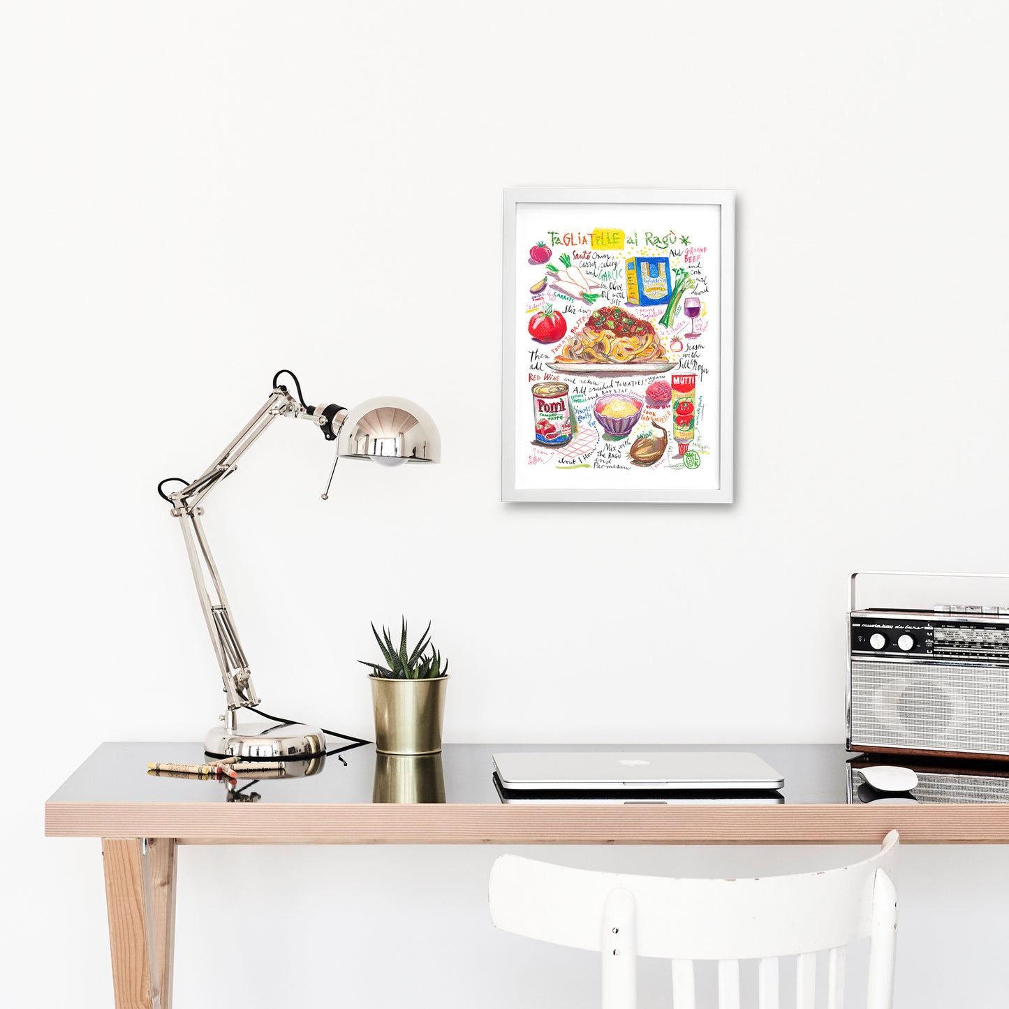 Tagliatelle al ragù recipe fine art print in oil pastel featuring the ingredients and the finished dish, along with handwritten instructions in English. The framed poster hanging in a working space.