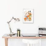 an aperol spritz recipe fine art print in watercolor featuring the ingredients and a glass filled with this cocktail, along with handwritten instructions in English. The framed poster hanging in a working space.