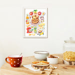 an apple cider donut recipe fine art print in watercolor featuring the ingredients and the finished dessert, along with handwritten instructions in English. The framed poster hanging in a dining space.