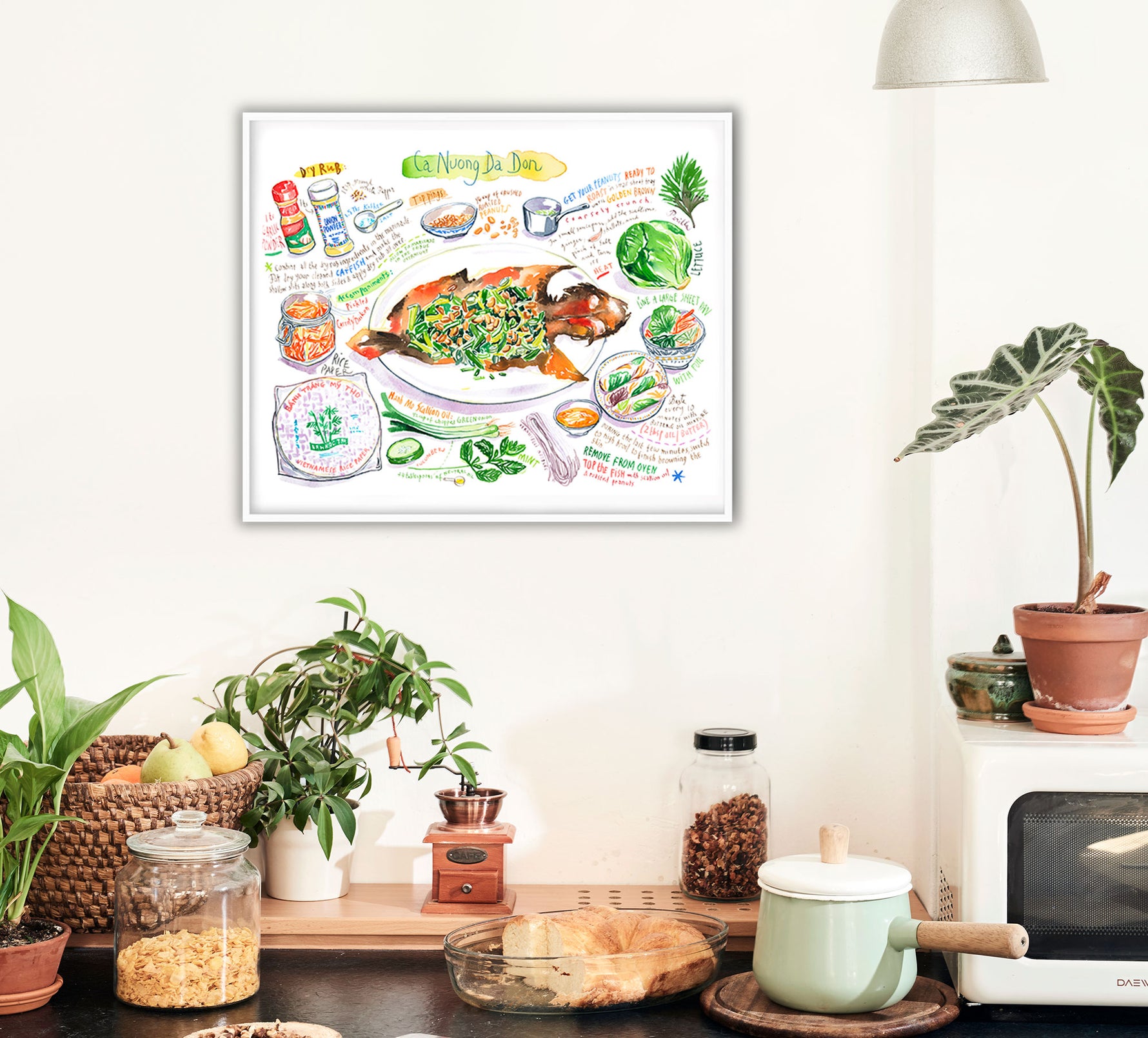 ca-nuong-da-don-recipe-print in watercolor featuring the ingredients and the finished dish, along with handwritten instructions in English. The horizontal framed poster hanging in a kitchen.