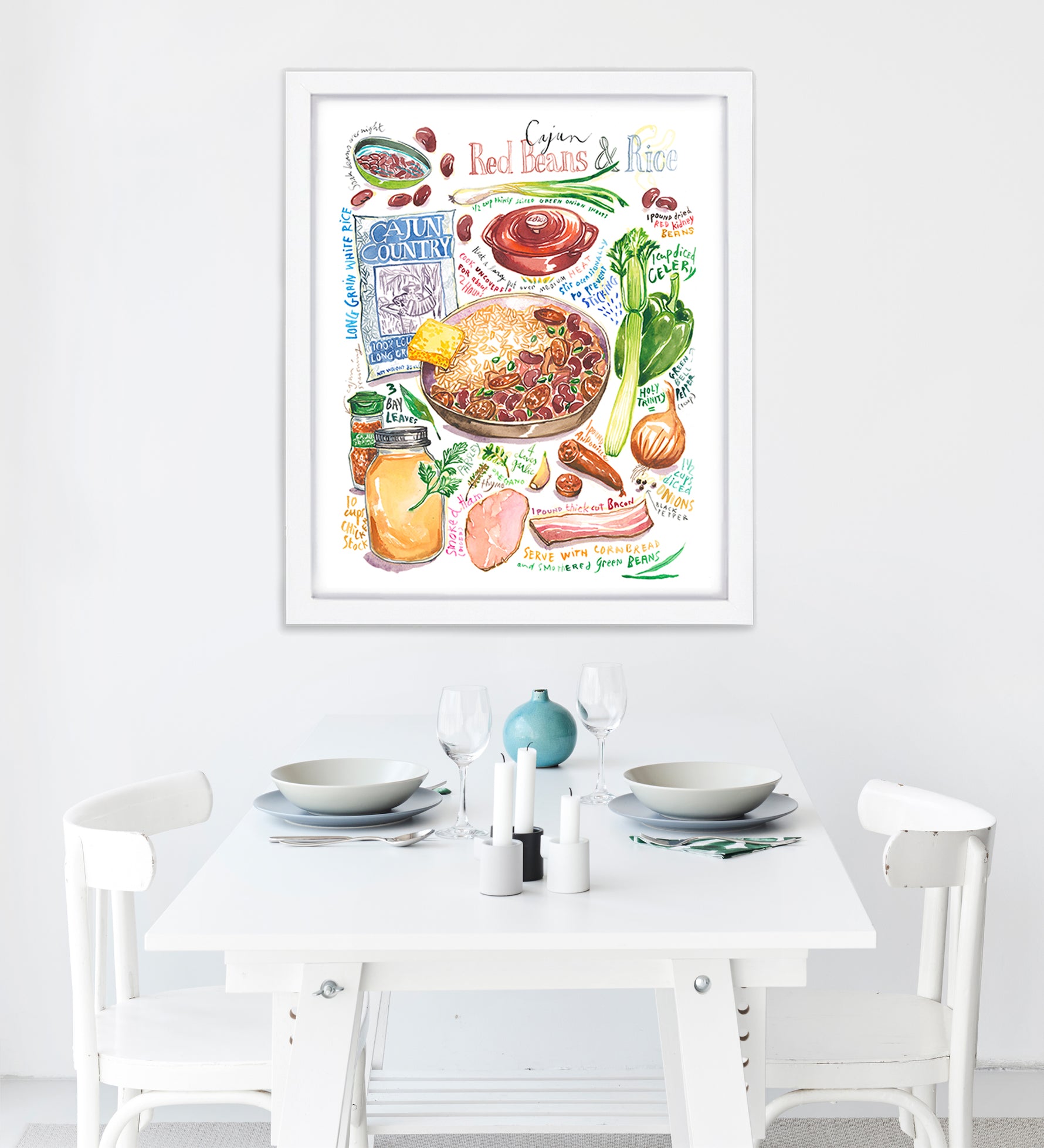 cajun red beans and rice recipe fine art print in watercolor featuring the ingredients and the finished dish, along with handwritten instructions in English. The framed poster hanging in a dining space.