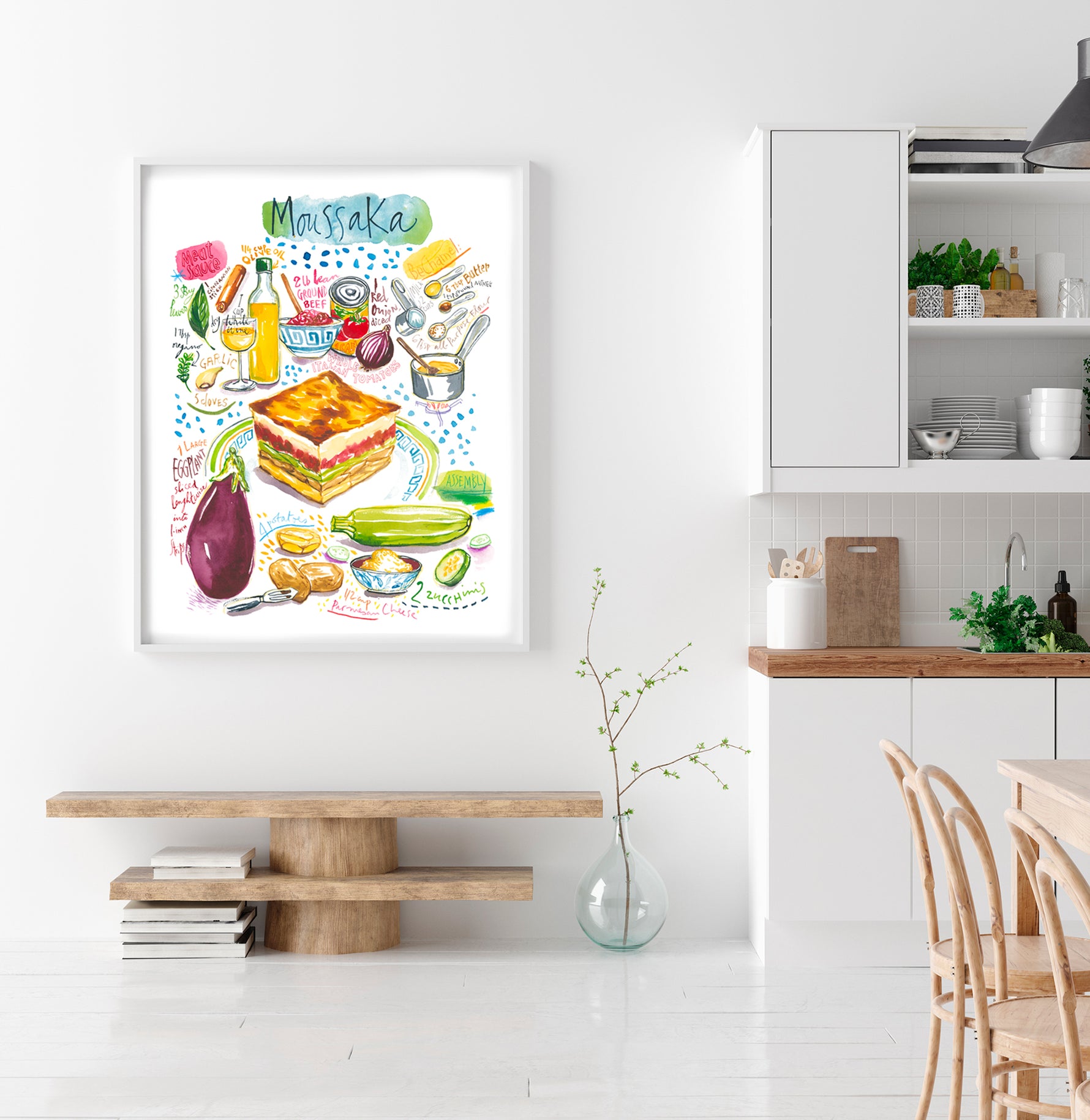 moussaka  recipe fine art print in watercolor featuring the ingredients and the finished dish, along with handwritten instructions in English. The framed poster hanging in a dining space.