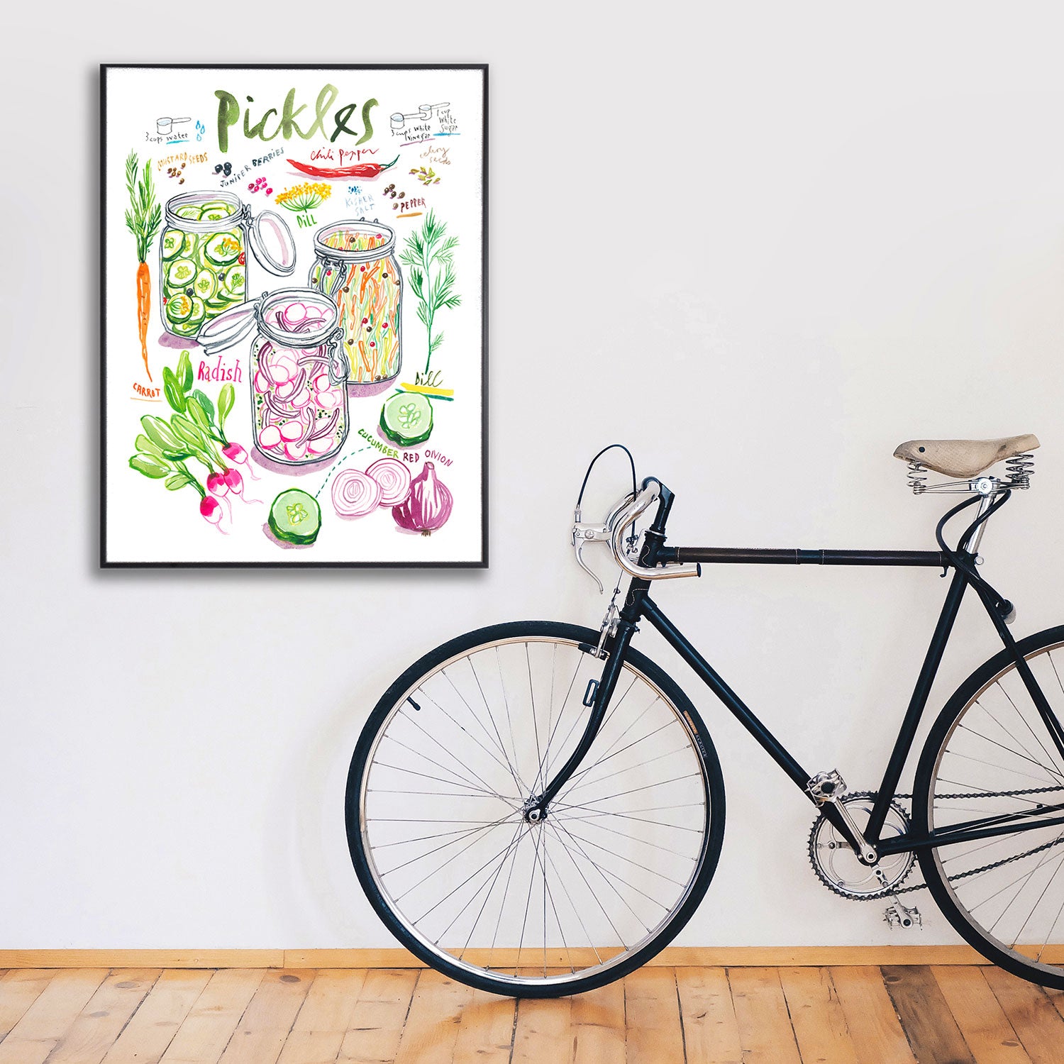 pickled vegetables recipe fine art print in watercolor featuring the ingredients and three jars of mixed veggies, along with handwritten instructions in English. The framed poster hanging in a home decor
