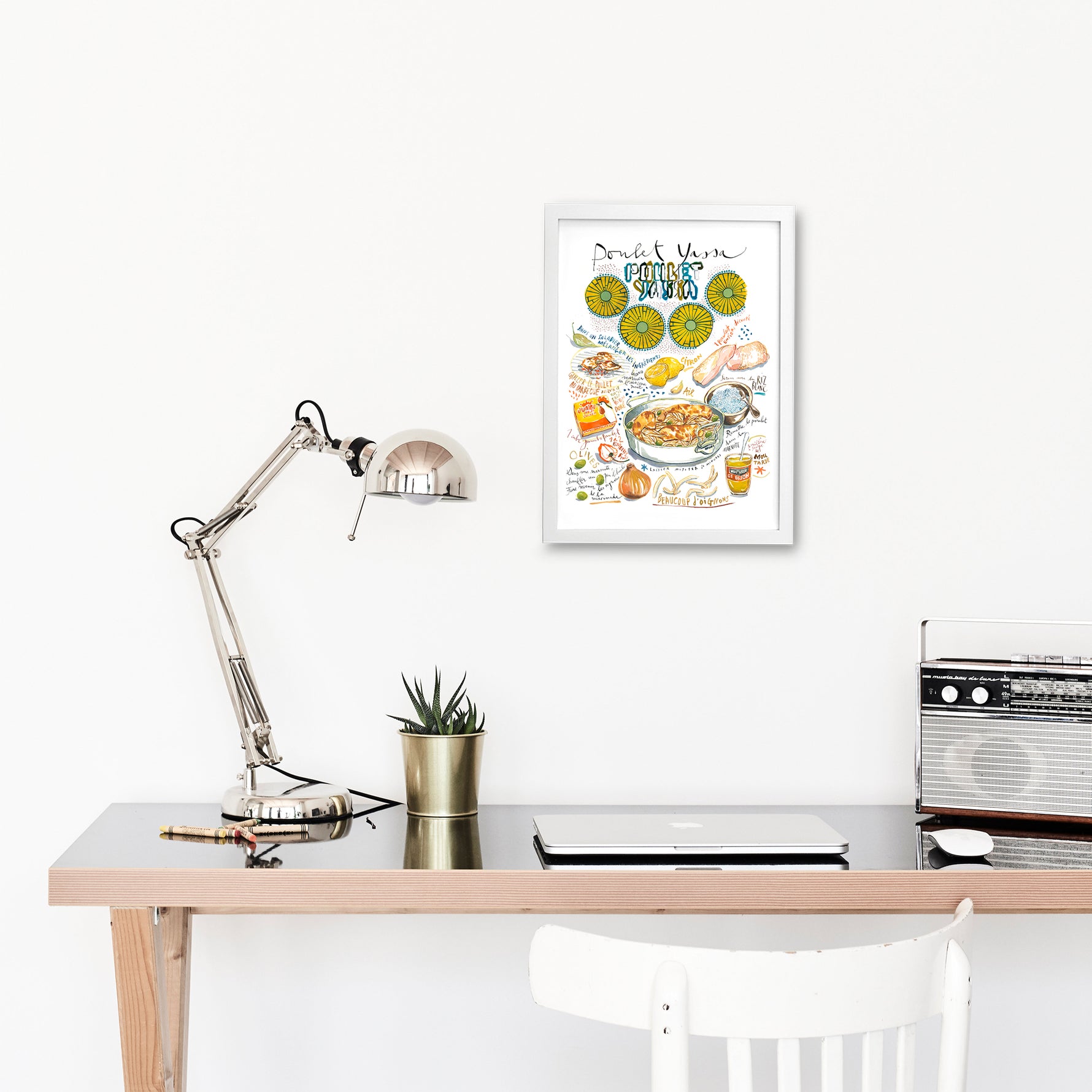 Senegalese yassa chicken recipe fine art print in watercolor featuring the ingredients and the finished dish, along with handwritten instructions in French. The framed poster hanging in a working space.