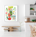 Spanish and Puerto Rican sofrito recipe fine art print in watercolor featuring the ingredients and the finished dish, along with handwritten instructions in English. The framed poster hanging in a dining space.