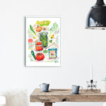 Spanish and Puerto Rican sofrito recipe fine art print in watercolor featuring the ingredients and the finished dish, along with handwritten instructions in English. The framed poster hanging in a dining space.